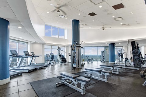 A spacious gym with a variety of equipment and a large window.