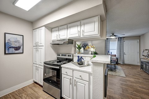 A kitchen with white cabinets and a stove top oven.