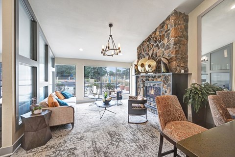 A living room with a stone wall and a fireplace.
