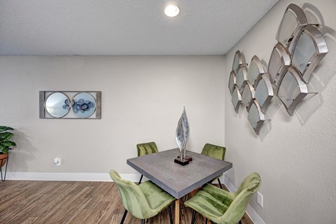 A dining room with a grey table and green chairs.