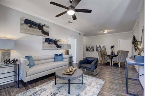 A living room with a white couch and a grey coffee table.