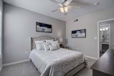 A bedroom with a large bed and a ceiling fan.
