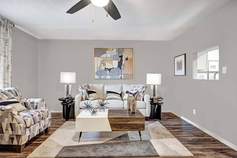 A living room with a couch, a chair, and a coffee table.