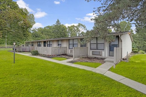 A long building with a green lawn in front.