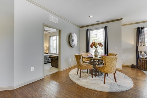 A dining room with a round table and chairs.