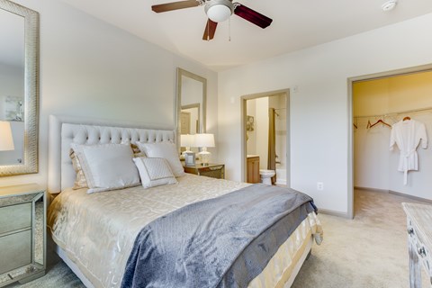 A bedroom with a large bed and a ceiling fan.