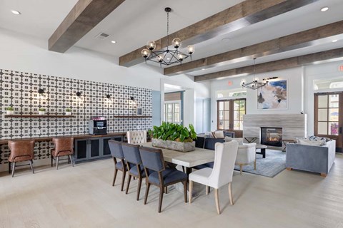 A modern dining room with a large table and chairs.
