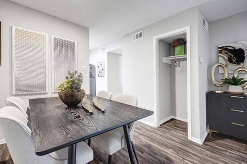 A dining room with a wooden table and white chairs.