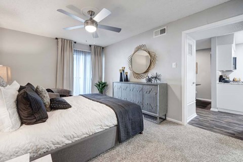 A bedroom with a large bed and a dresser with a mirror.