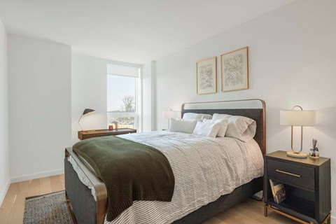 A bedroom with a large bed and a window.