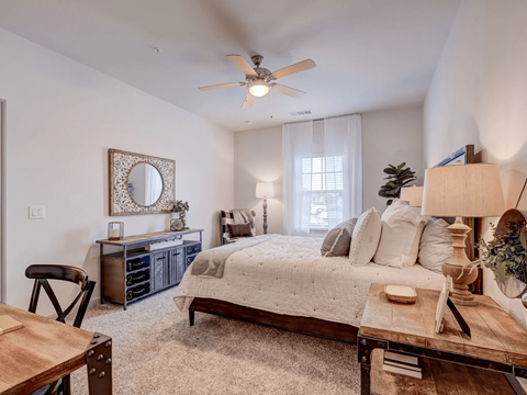 A bedroom with a bed, dresser, and mirror.