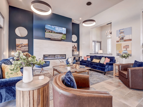 A living room with a blue couch and a fireplace.