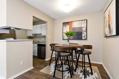 A kitchen with a dining table and chairs.