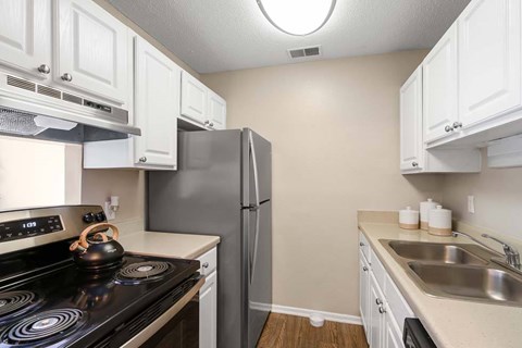 A kitchen with white cabinets and a black stove top.