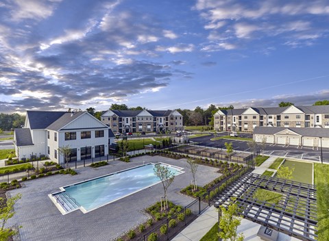 A large white building with a pool in front of it.