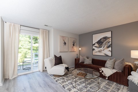 A living room with a white couch, a coffee table, and a painting on the wall.