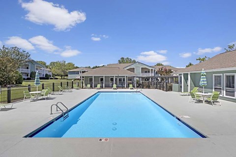 A large blue swimming pool in the middle of a sunny day.