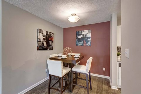 A dining room with a table and chairs.