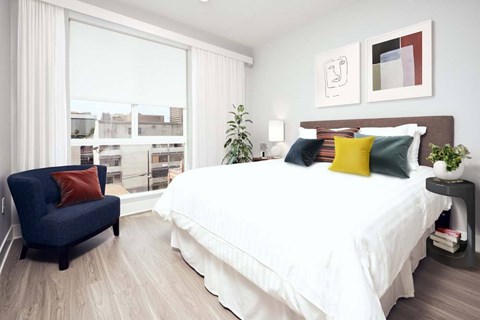 A bedroom with a large bed and a blue chair.
