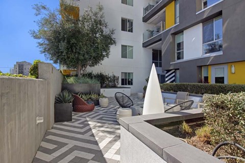 A modern outdoor patio area with a white sculpture and a pool.