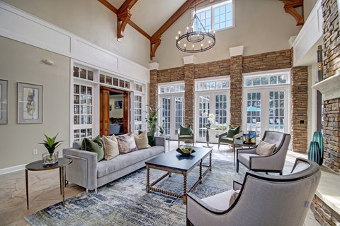 A living room with a grey couch, a coffee table, and a chandelier.