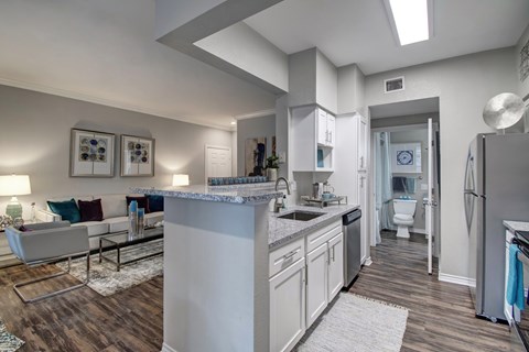 A modern kitchen with a white countertop and a white fridge.