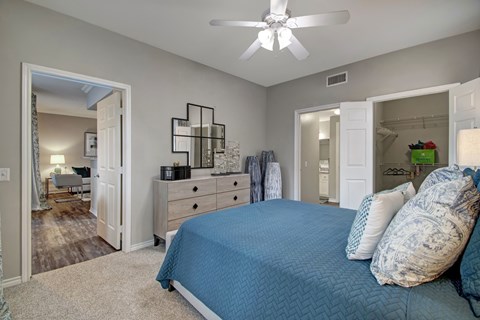A bedroom with a bed, dresser, and mirror.