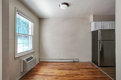 A room with a window and a refrigerator.