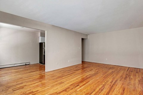 A room with wooden flooring and white walls.