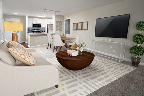 A living room with a white couch and a flat screen TV mounted on the wall.