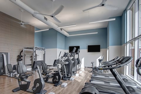 A gym with treadmills, weights, and exercise equipment.
