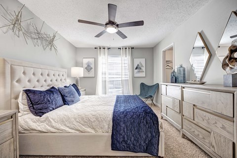A bedroom with a bed, dresser, and mirror.