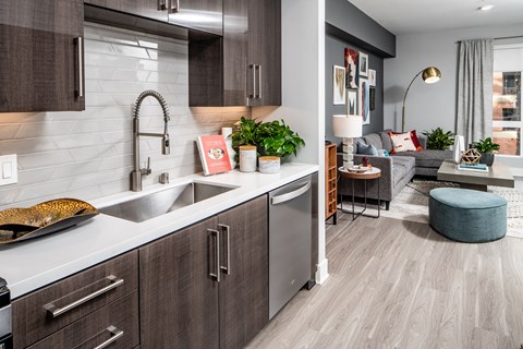 A modern kitchen with dark wood cabinets and a white backsplash.