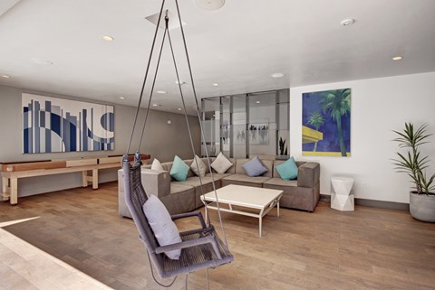 A modern living room with a hanging chair and a sofa.
