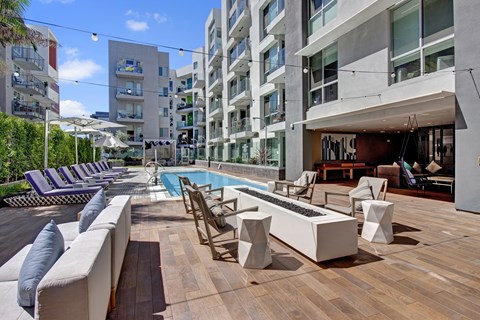 A modern outdoor seating area with a pool and lounge chairs.