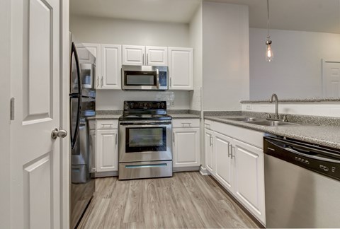 A kitchen with white cabinets and stainless steel appliances.