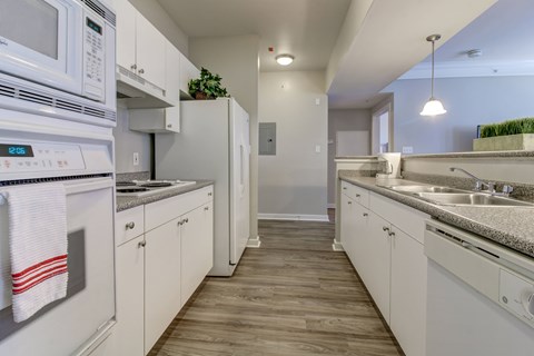 A kitchen with white appliances and cabinets.