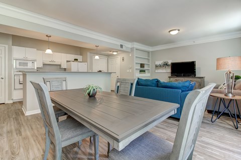 A dining room with a wooden table and grey chairs.