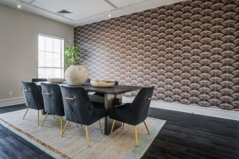 A dining room with a table and chairs.