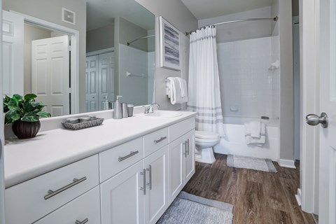 A white bathroom with a toilet, sink, and mirror.