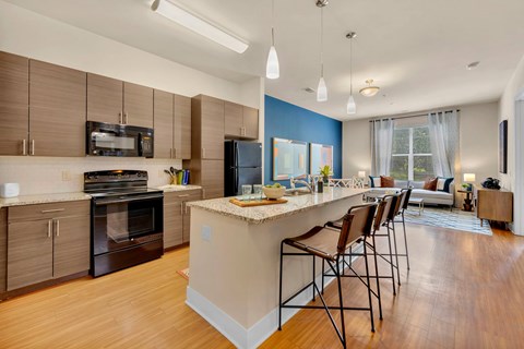 A kitchen with a blue wall and wooden floors.
