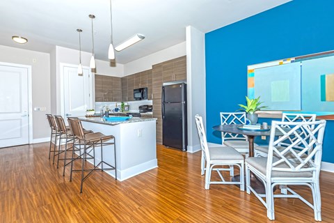 A kitchen with a blue wall and wooden floors.