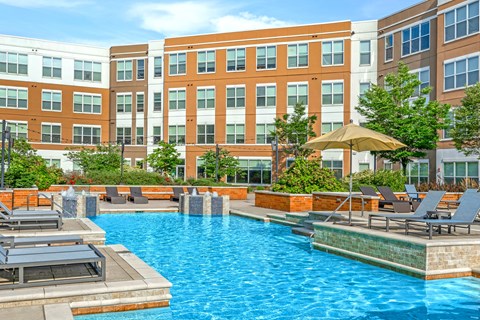 A pool area with sun loungers and a yellow umbrella.