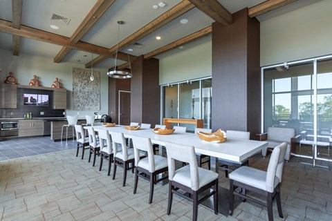 A long table with chairs is set for a meal in a modern dining room.