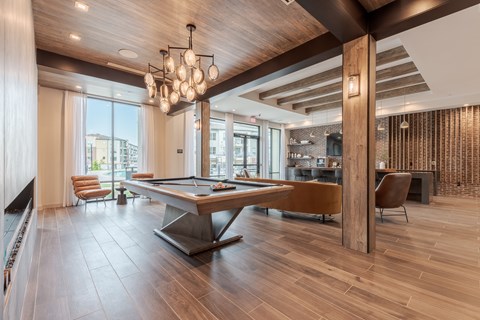 A modern room with a pool table and a bar.