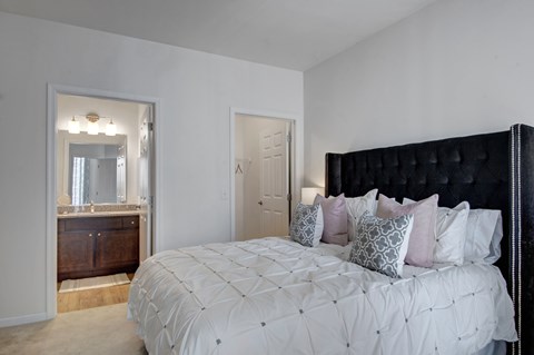 A bedroom with a large bed and a mirror on the wall.