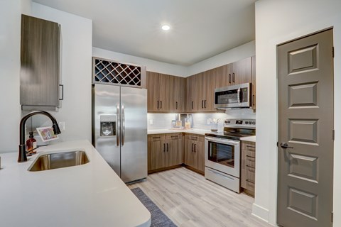 A modern kitchen with wooden cabinets and stainless steel appliances.