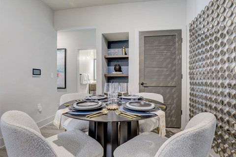A modern dining room with a round table set for six.