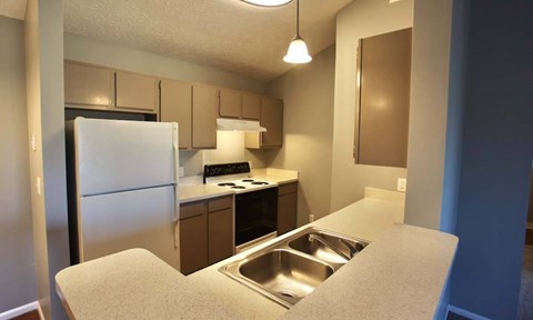 A kitchen with a sink and a refrigerator.