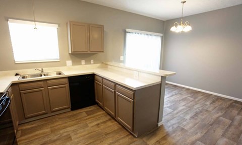 A kitchen with wooden floors and cabinets.
